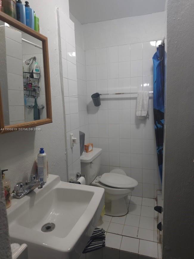 9021 Southwest 30th Terrace Miami, FL 33165 - Photo 18 of 18 a bathroom with a sink and mirror with toilet