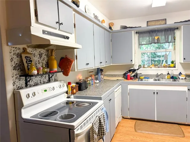 a kitchen with a sink stove and cabinets