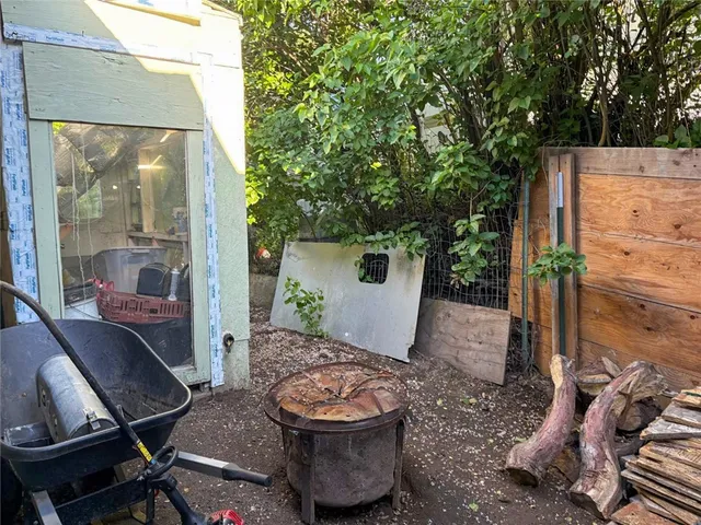 a backyard of a house with barbeque oven table and chairs