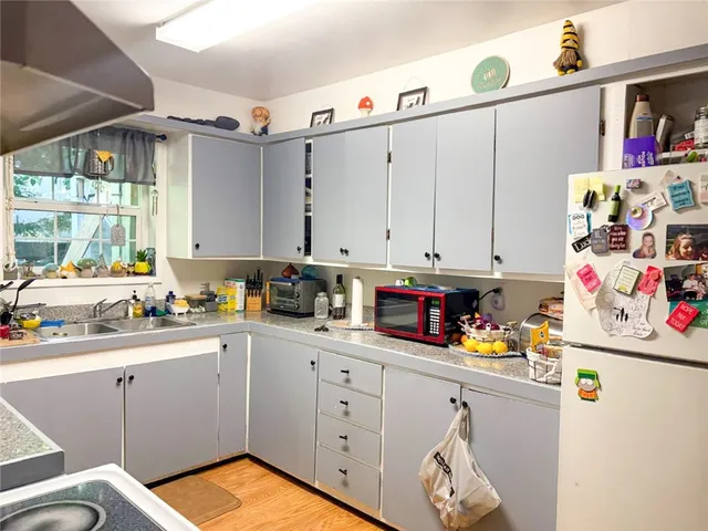 a kitchen with granite countertop white cabinets and white appliances