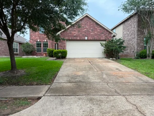 a front view of a house with a garden and trees