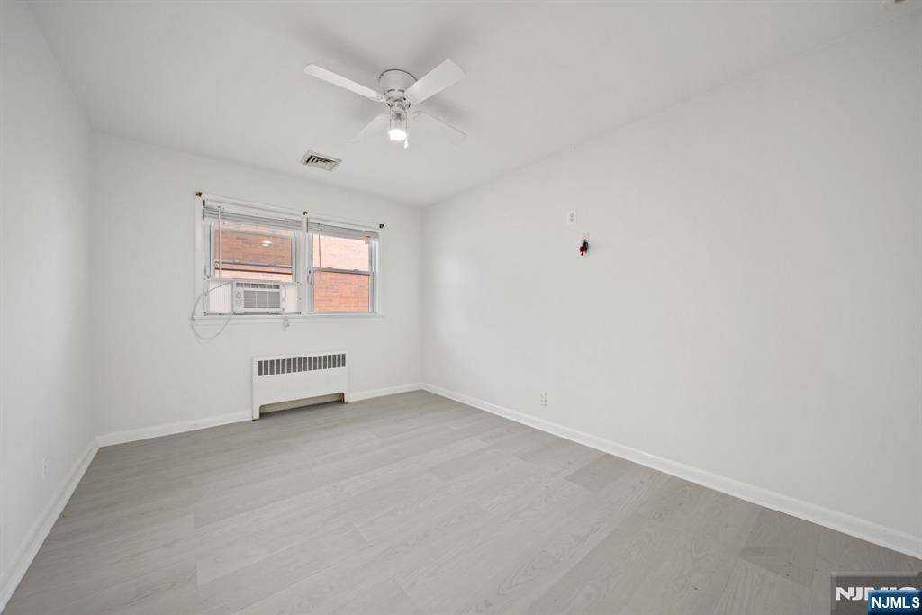 23 Arn Terrace, Unit 1 Secaucus, NJ 07094 - Photo 11 of 22 an empty room with windows and ceiling fan