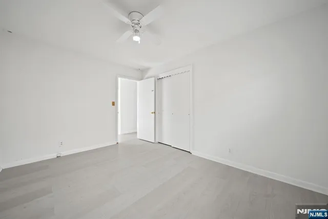 an empty room with a ceiling fan and a window