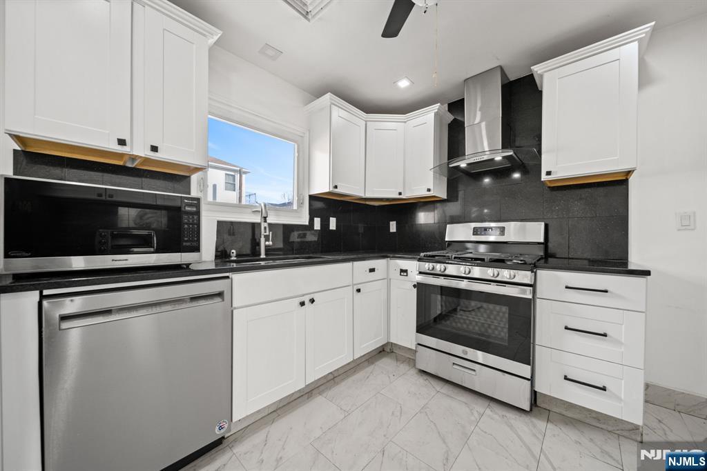 23 Arn Terrace, Unit 1 Secaucus, NJ 07094 - Photo 8 of 22 a kitchen with granite countertop white cabinets and stainless steel appliances