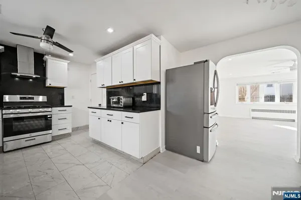 a kitchen with stainless steel appliances white cabinets and a refrigerator