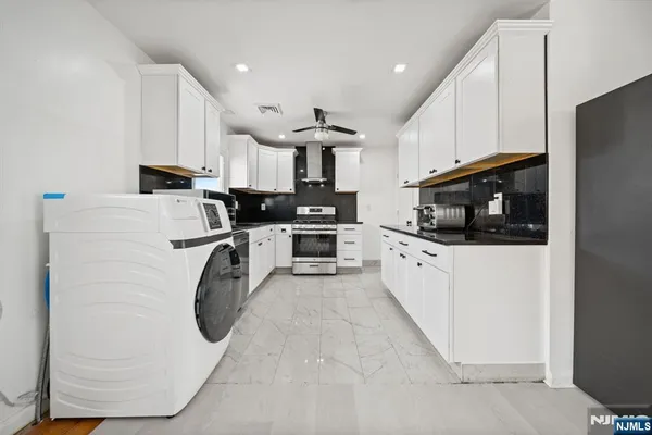 a kitchen with white cabinets and white appliances
