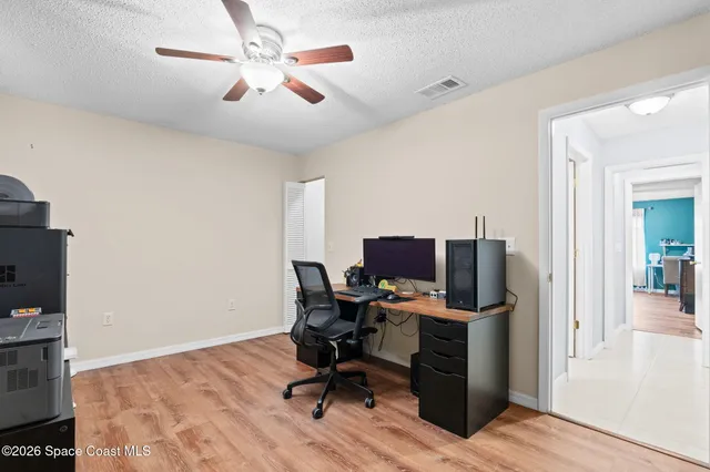 a view of a workspace with furniture and a window