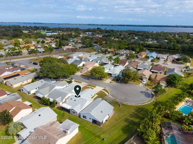 an aerial view of a house with garden space and ocean view