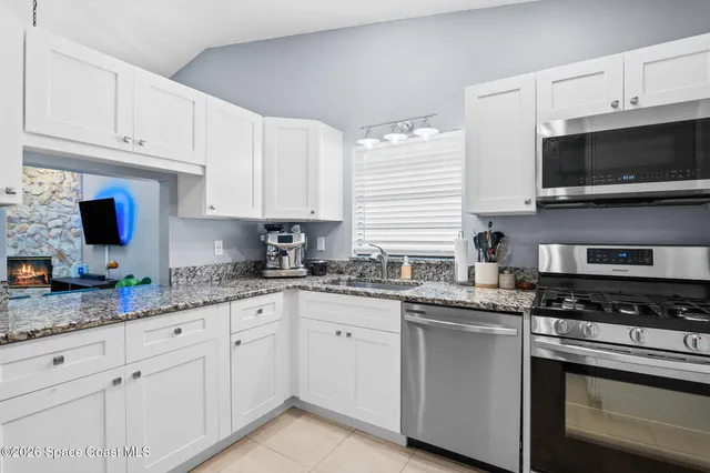 a kitchen with granite countertop a sink and a stove