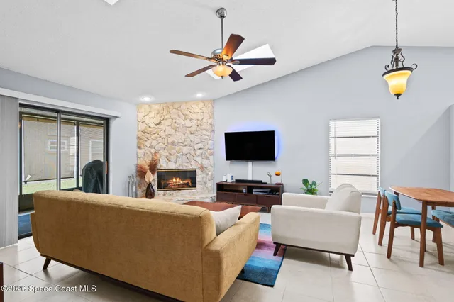 a living room with furniture a chandelier and a flat screen tv