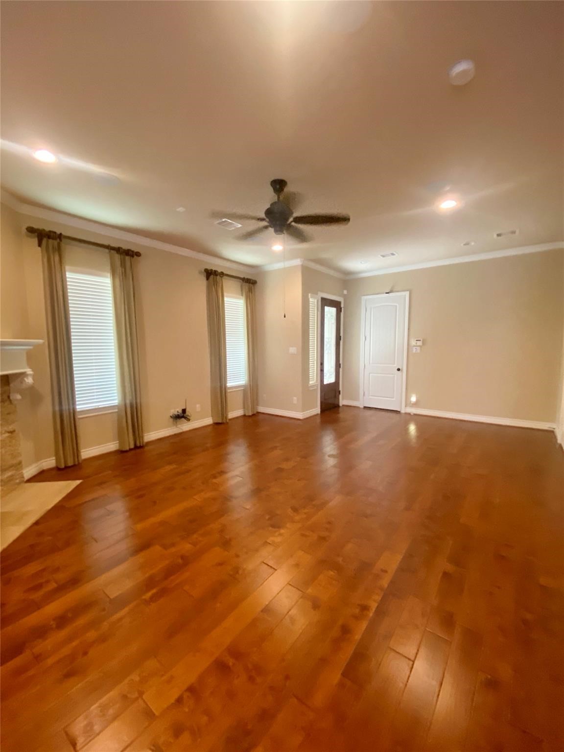 an empty room with ceiling fan and window