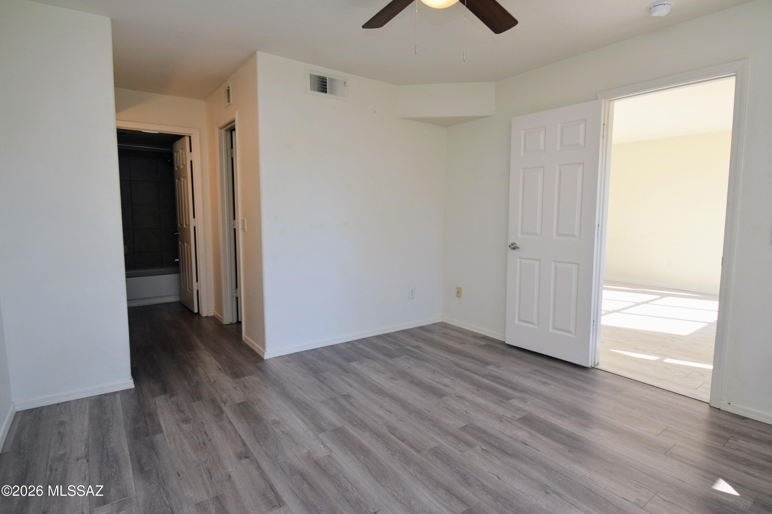 5855 North Kolb Road, Unit 11106 Tucson, AZ 85750 - Photo 22 of 36 a view of an empty room with wooden floor and a window