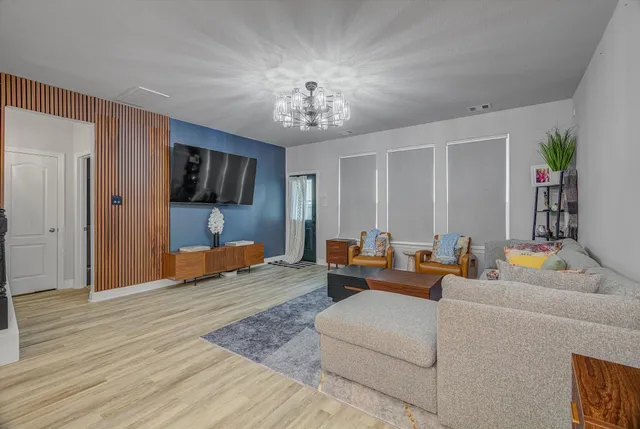 an empty room with wooden floor cabinet and windows