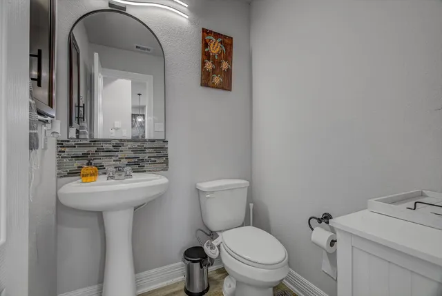 a bathroom with a sink a toilet a mirror and vanity