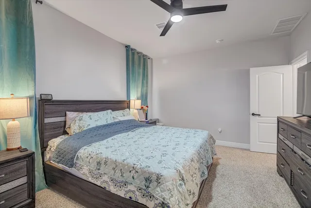 a bedroom with a bed and a flat tv screen on the dresser