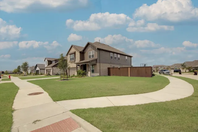 a view of a big house with a big yard and a large trees
