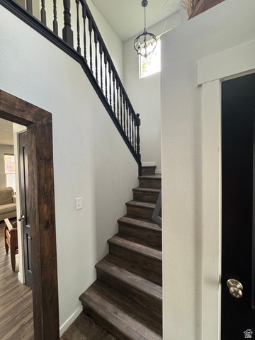 1237 South 260 West Payson, UT 84651 - Photo 27 of 81 Dramatic open staircase featuring dark wood-finish treads, black metal railings, and soaring ceilings with natural light from above