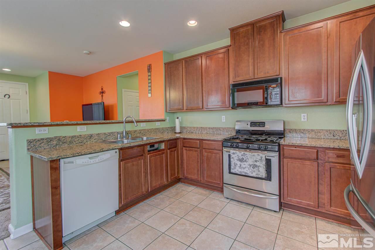 9045 Convair Way Reno, NV 89506 - Photo 12 of 34 a kitchen with stainless steel appliances granite countertop a stove top oven a sink and dishwasher