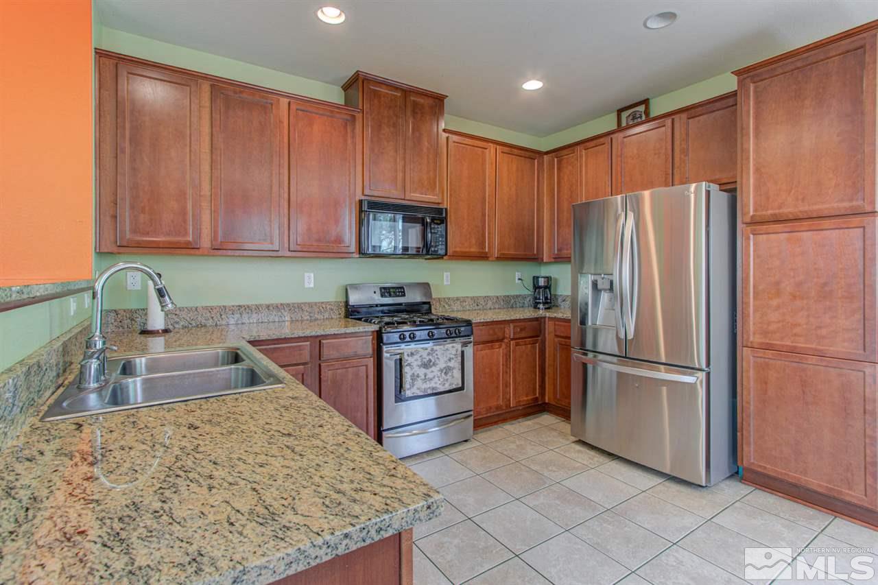9045 Convair Way Reno, NV 89506 - Photo 13 of 34 a kitchen with stainless steel appliances granite countertop a refrigerator sink and microwave