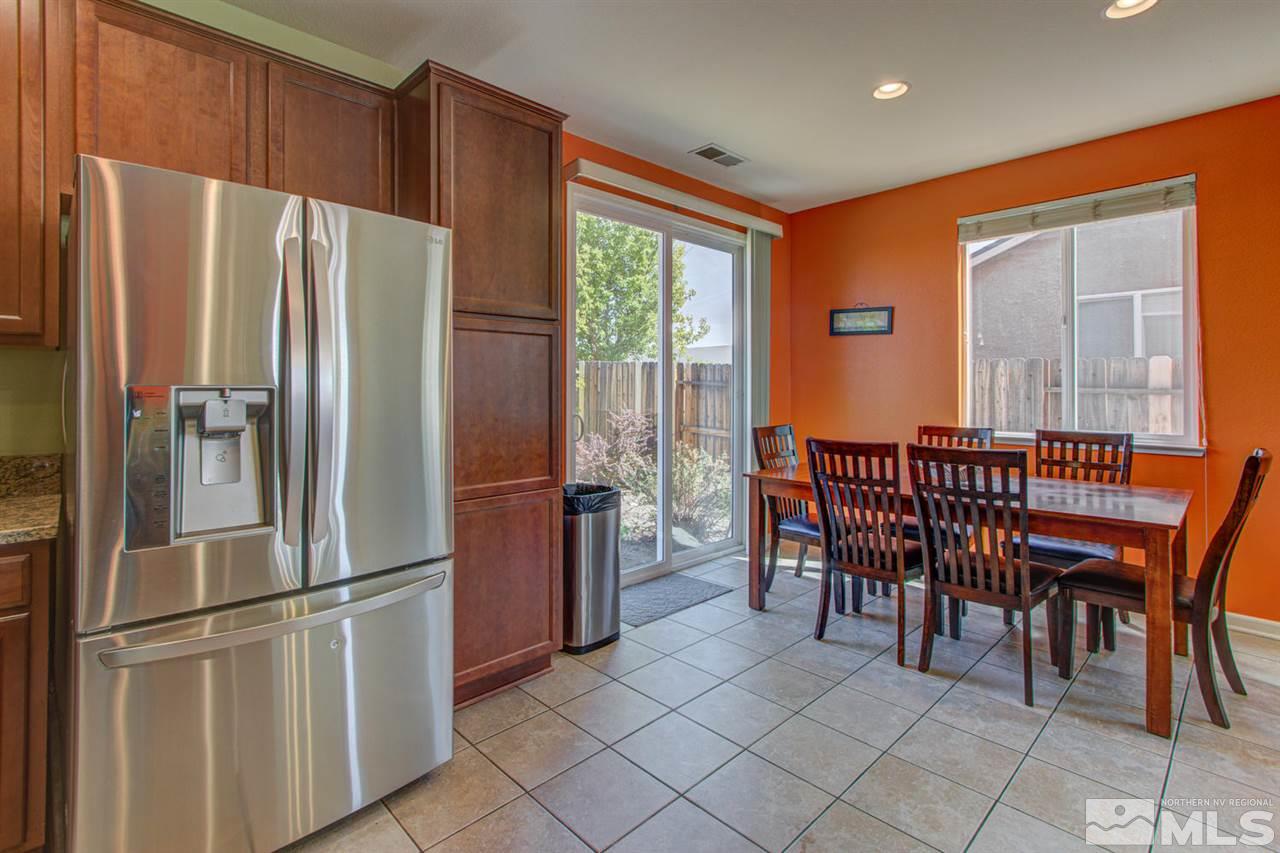 9045 Convair Way Reno, NV 89506 - Photo 14 of 34 a kitchen with stainless steel appliances granite countertop a refrigerator a stove a dining table and chairs