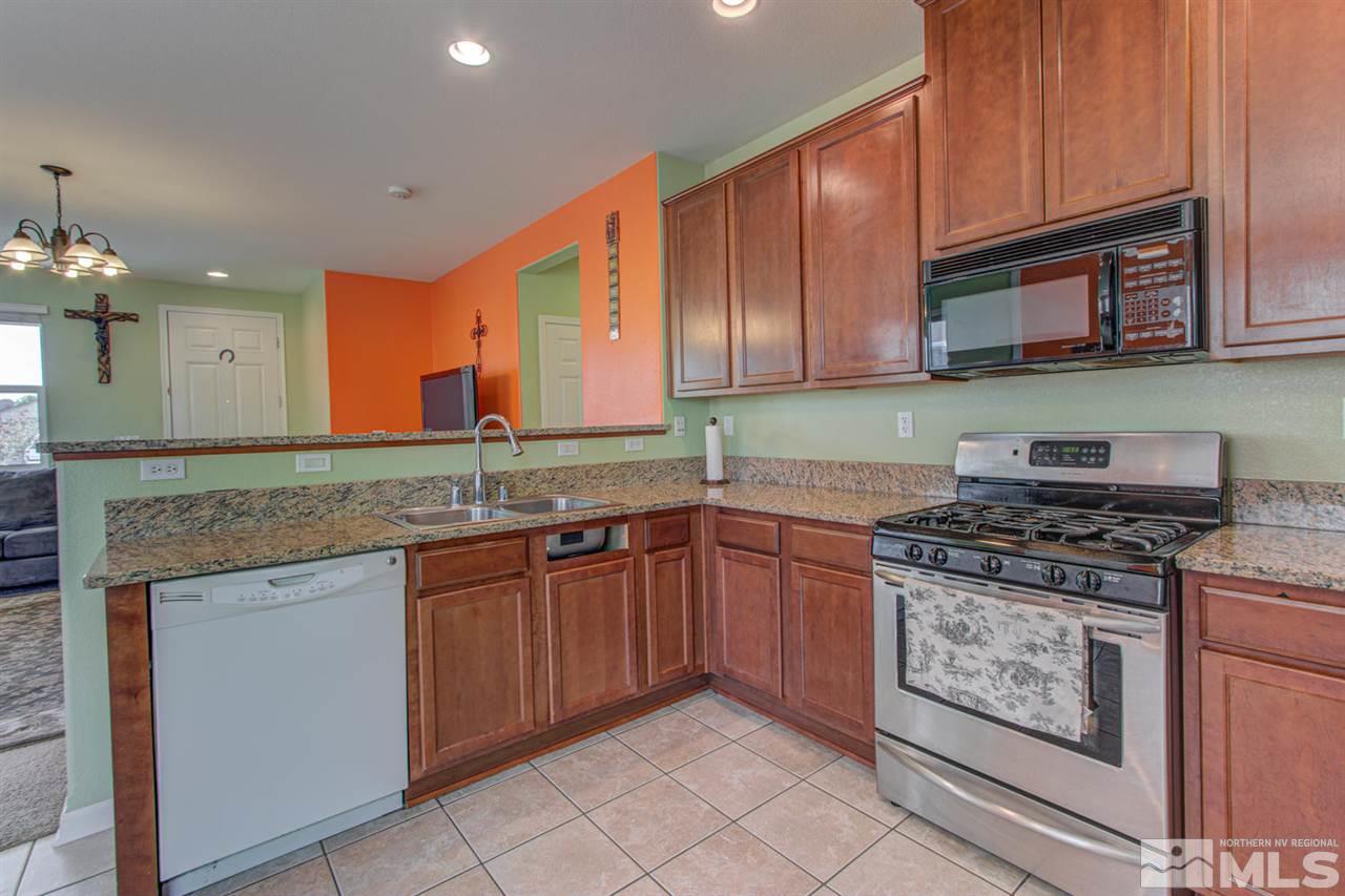 9045 Convair Way Reno, NV 89506 - Photo 16 of 34 a kitchen with stainless steel appliances granite countertop a stove a sink and a microwave