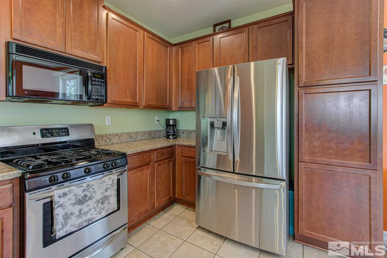9045 Convair Way Reno, NV 89506 - Photo 17 of 34 a kitchen with stainless steel appliances granite countertop a refrigerator and a stove top oven