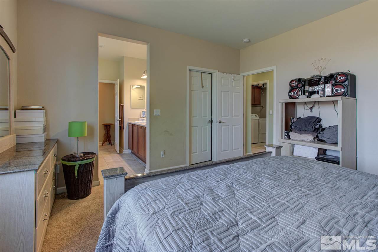 9045 Convair Way Reno, NV 89506 - Photo 26 of 34 a spacious bedroom with a bed and a desk in it