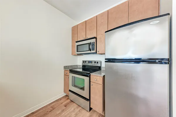 a kitchen with stainless steel appliances granite countertop a stove a microwave and a refrigerator