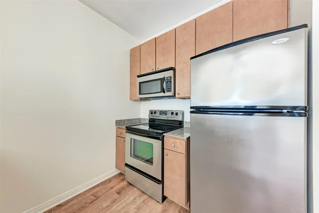 a kitchen with stainless steel appliances granite countertop a stove a microwave and a refrigerator