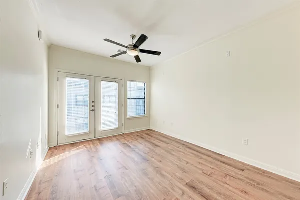 a view of an empty room with a window and wooden floor