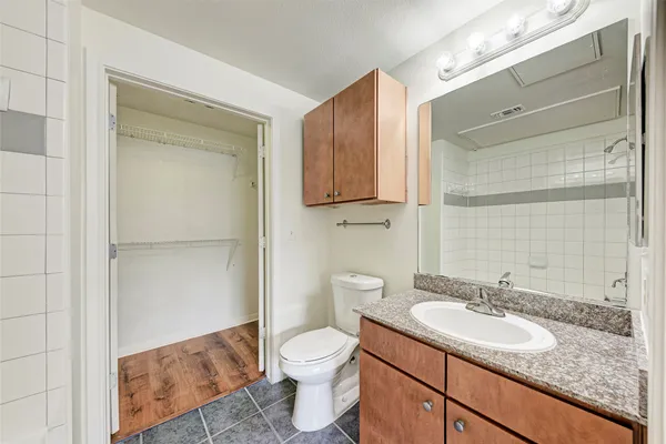 a bathroom with a granite countertop sink toilet and shower