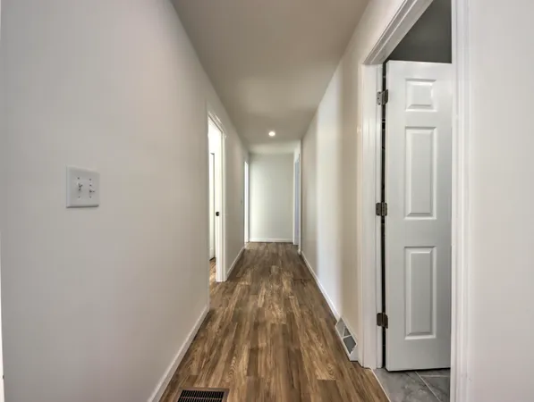 a view of a hallway with wooden floor and entryway