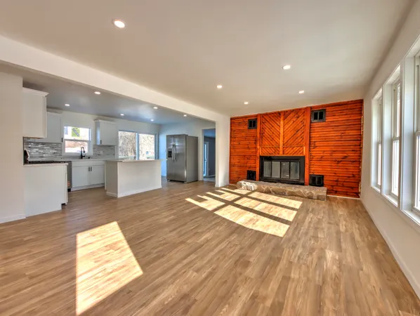 a view of empty room with wooden floor and fireplace