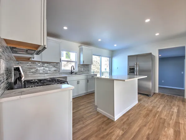 a kitchen with stainless steel appliances kitchen island wooden cabinets and granite counter tops