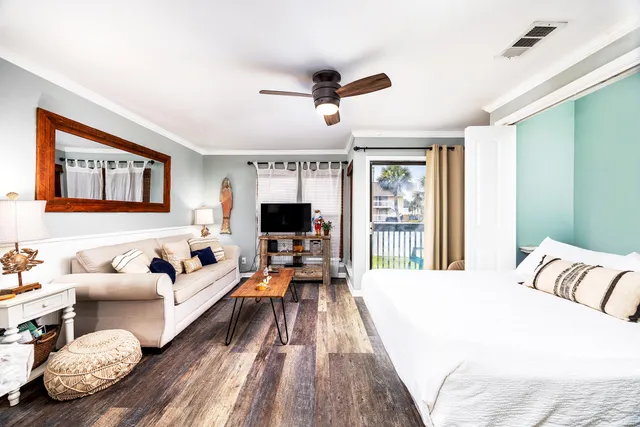 a bedroom with a bed a lamp and a large window