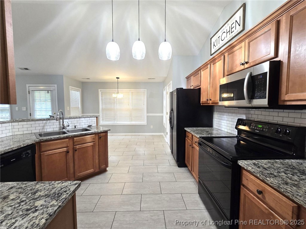 4158 Redspire Lane Fayetteville, NC 28306 - Photo 15 of 34 a kitchen with stainless steel appliances granite countertop a stove a sink and a microwave