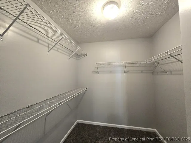 a view of an empty room and chandelier fan