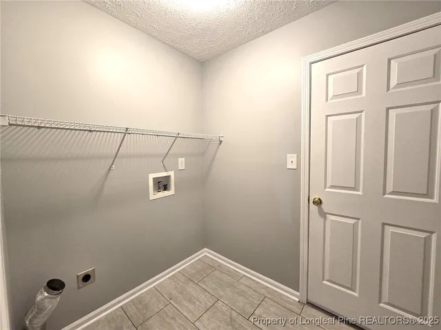 an empty room with a chandelier fan and windows