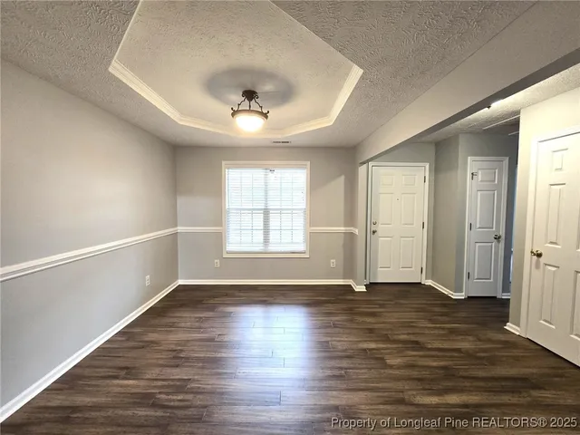 an empty room with wooden floor fireplace and windows