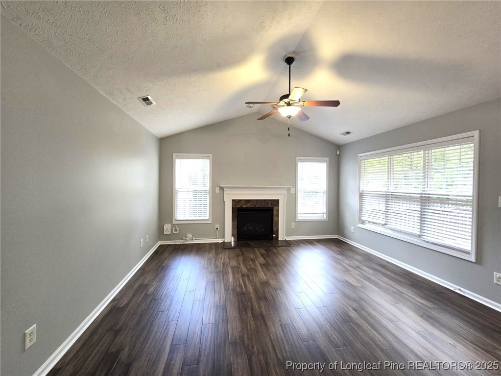 4158 Redspire Lane Fayetteville, NC 28306 - Photo 8 of 34 an empty room with wooden floor fireplace and windows