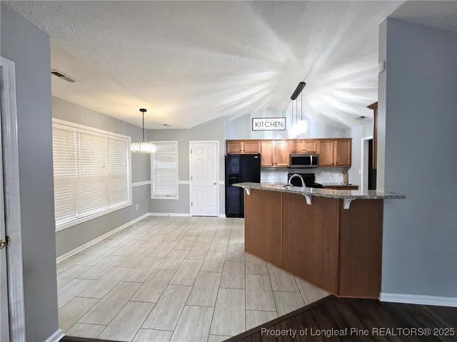 a kitchen with stainless steel appliances granite countertop a refrigerator and a stove top oven