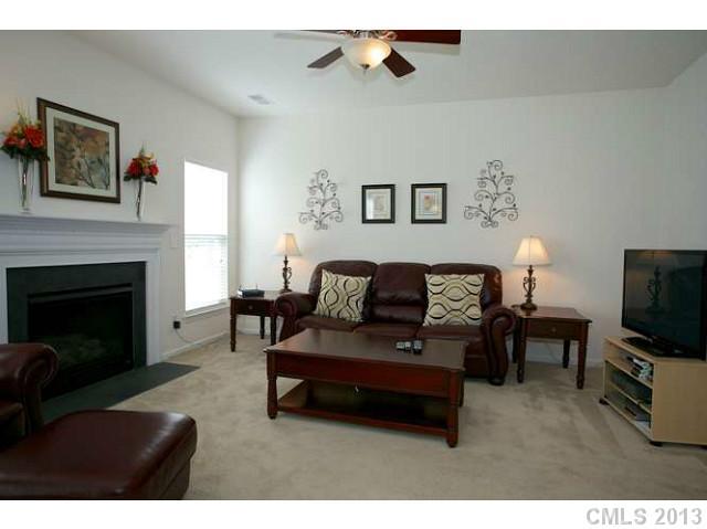 7312 April Mist Trail Huntersville, NC 28078 - Photo 5 of 11 a living room with furniture a flat screen tv and a fireplace