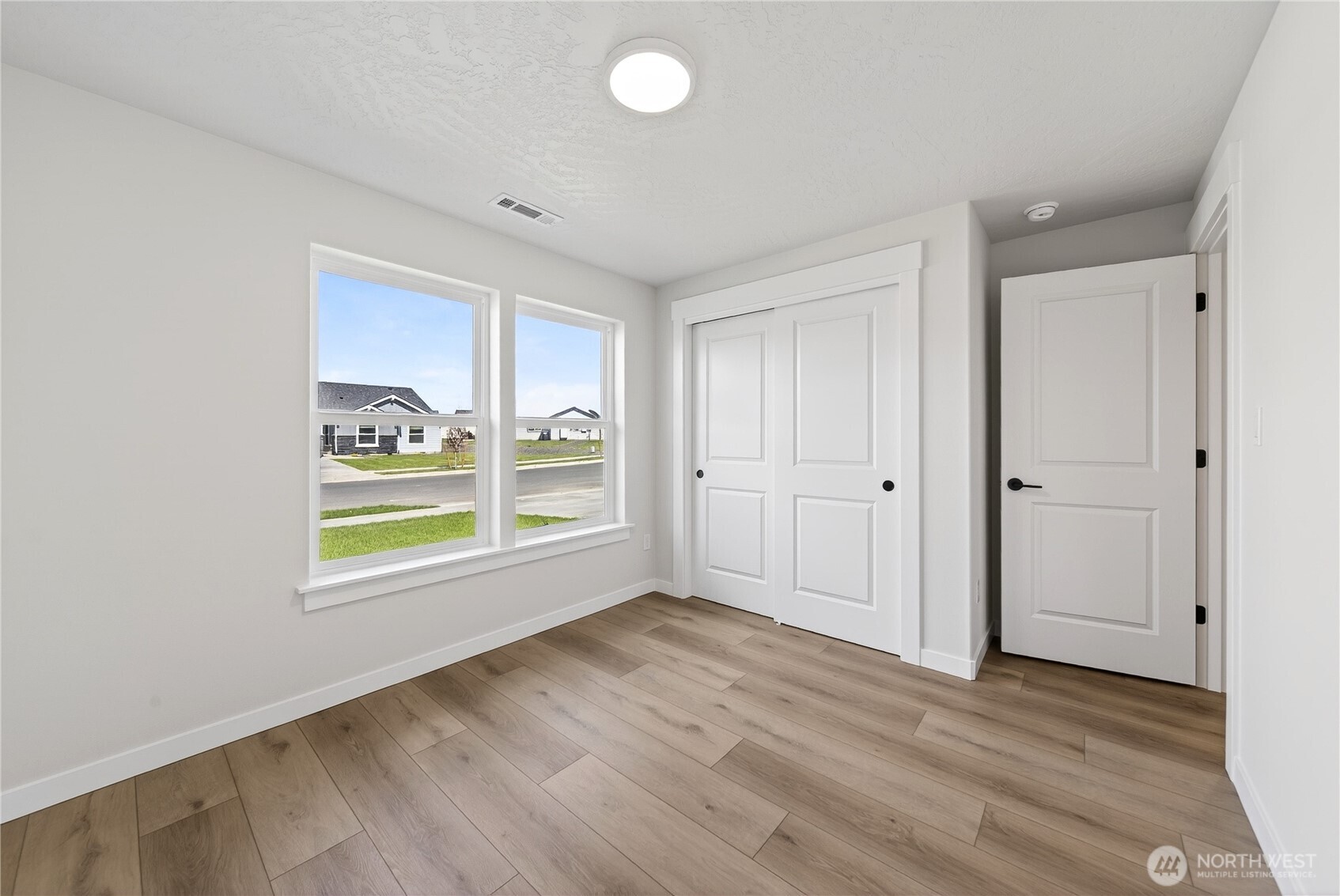 783 Ava Street Walla Walla, WA 99362 - Photo 5 of 12 an empty room with wooden floor and windows