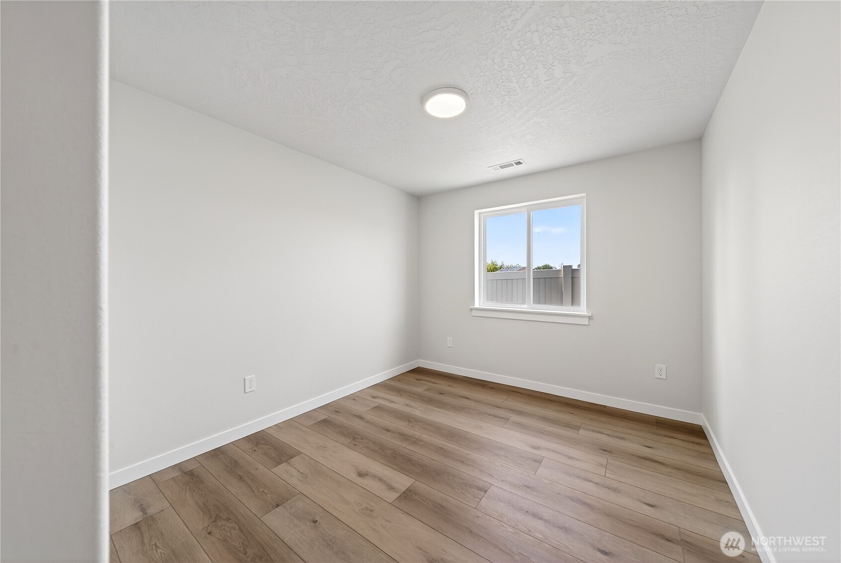 783 Ava Street Walla Walla, WA 99362 - Photo 6 of 12 a view of an empty room with wooden floor and a window