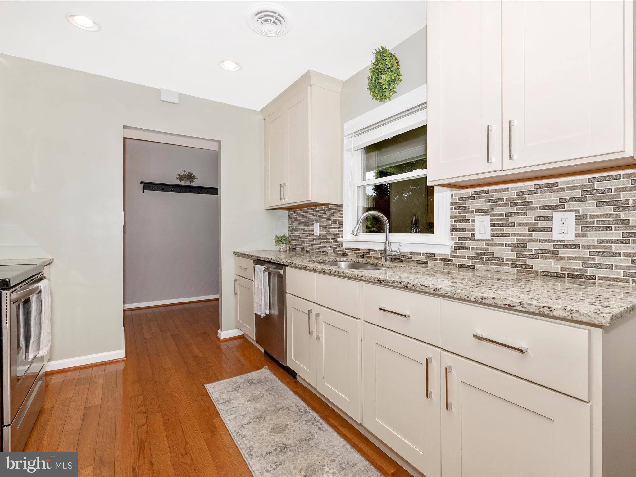 9204 Oak Tree Circle Frederick, MD 21701 - Photo 14 of 58 a kitchen with granite countertop a sink cabinets and wooden floor