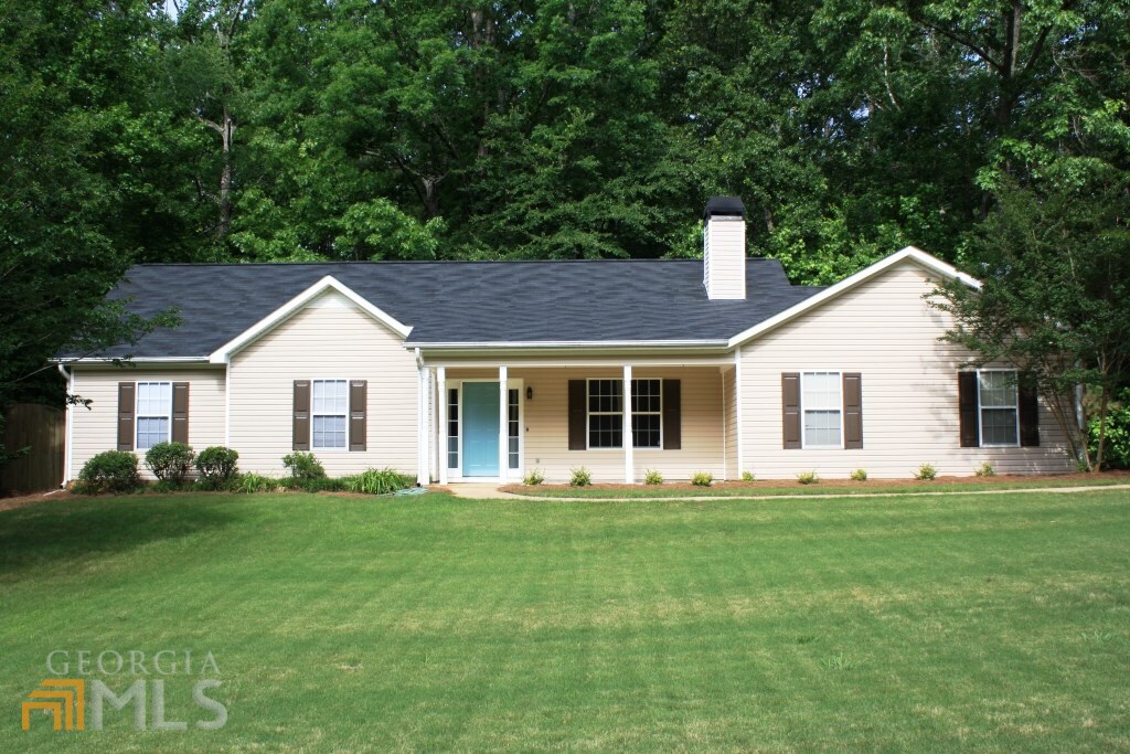 a front view of house with a garden and trees