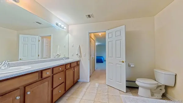 a spacious bathroom with a granite countertop sink mirror and toilet