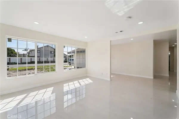 a large white kitchen with granite countertop a sink and dishwasher a stove with wooden floors