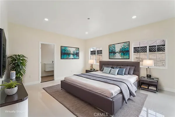 a bedroom with a large bed and a potted plant