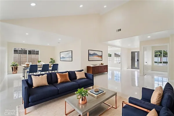 a view of a dining room and livingroom with furniture wooden floor and a potted plant